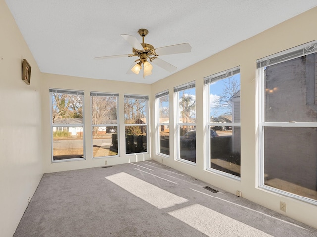 unfurnished sunroom with ceiling fan