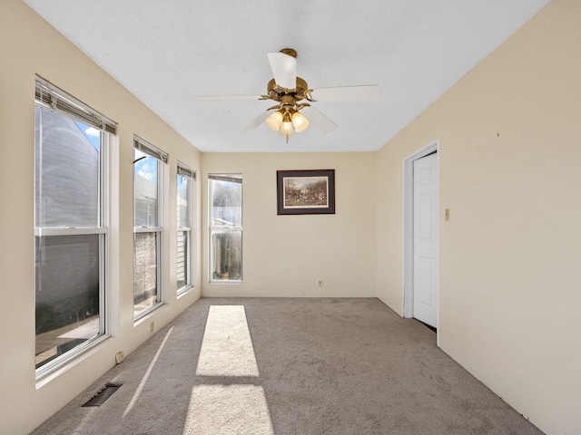 spare room featuring ceiling fan and light carpet