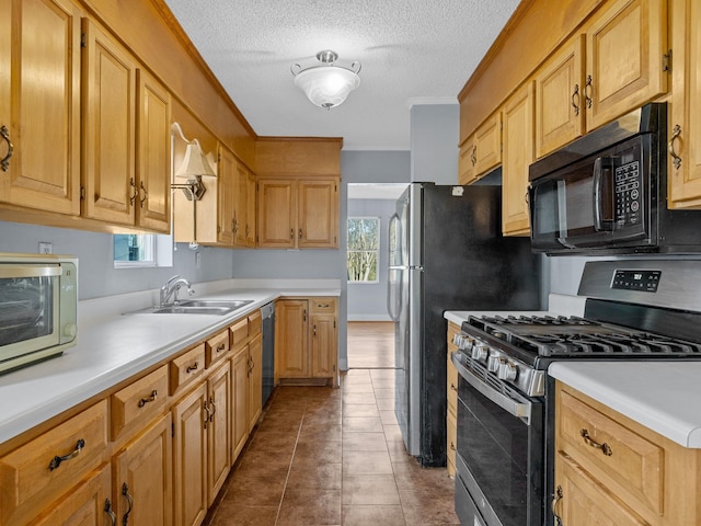 kitchen with a textured ceiling, appliances with stainless steel finishes, dark tile patterned flooring, and sink