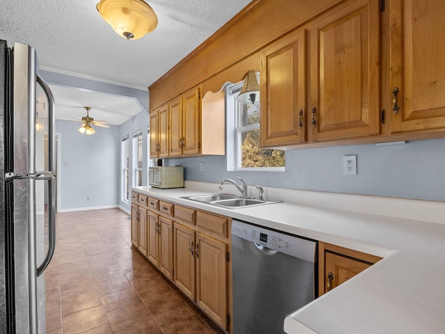 kitchen featuring plenty of natural light, sink, stainless steel appliances, and a textured ceiling