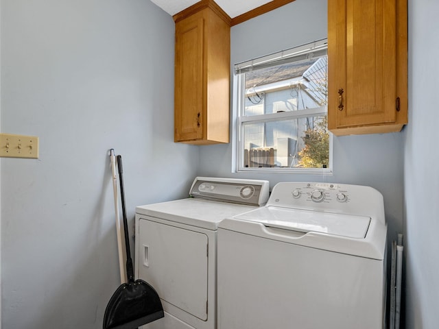 clothes washing area featuring independent washer and dryer and cabinets