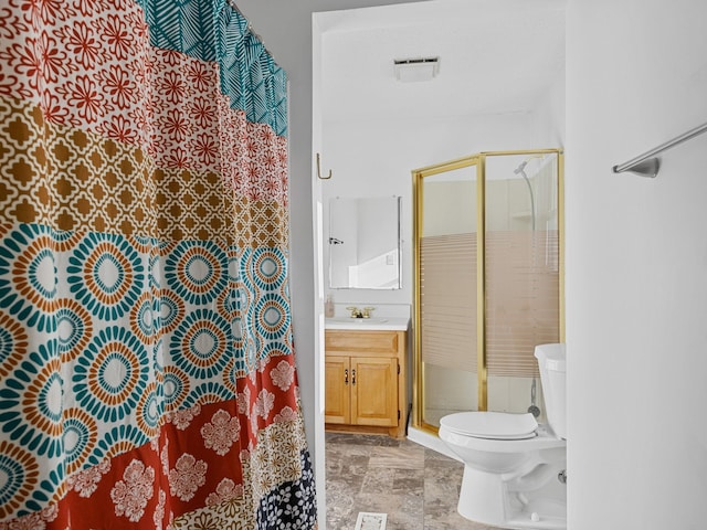 bathroom with toilet, vanity, and walk in shower