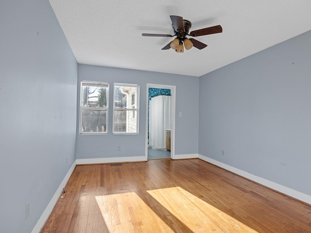 empty room featuring a textured ceiling, ceiling fan, and hardwood / wood-style flooring