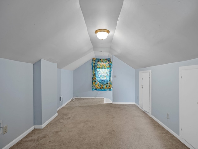 additional living space with light carpet and lofted ceiling