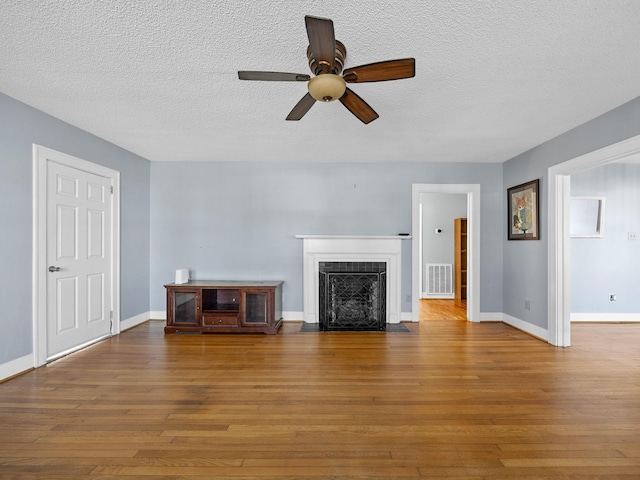 unfurnished living room featuring ceiling fan, wood-type flooring, and a textured ceiling