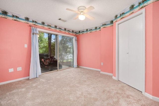 unfurnished bedroom featuring a textured ceiling, ceiling fan, and light colored carpet