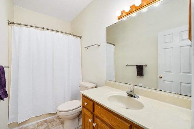 bathroom featuring toilet, vanity, and walk in shower