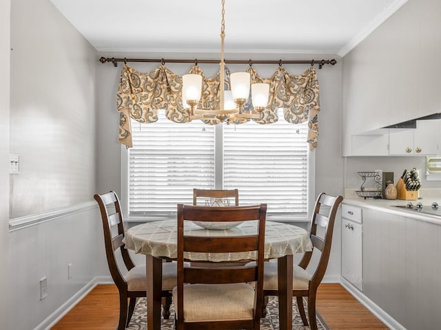 dining area featuring light hardwood / wood-style flooring, crown molding, and a healthy amount of sunlight