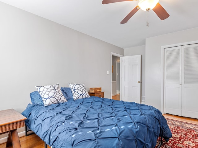 bedroom featuring ceiling fan, a closet, and wood-type flooring