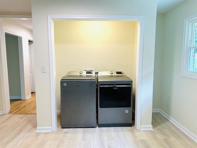 laundry room with light hardwood / wood-style floors and washer and clothes dryer