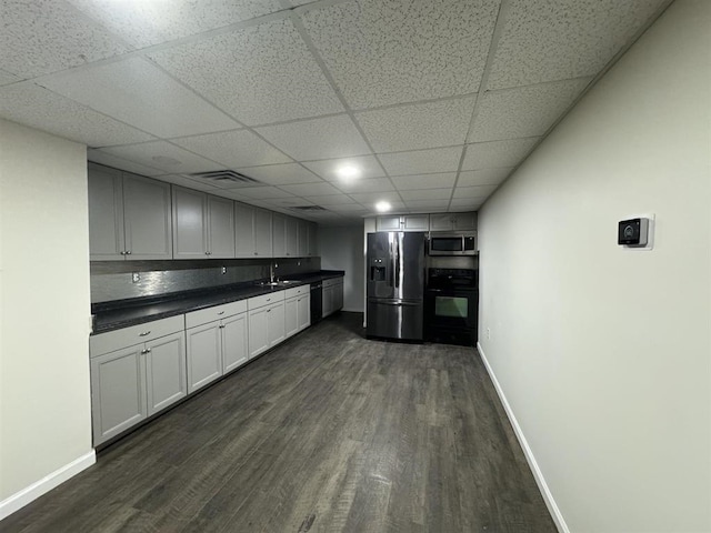 kitchen with dark wood-type flooring, sink, backsplash, and black appliances