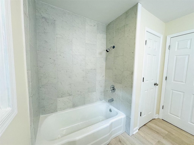 bathroom with tiled shower / bath combo and hardwood / wood-style floors