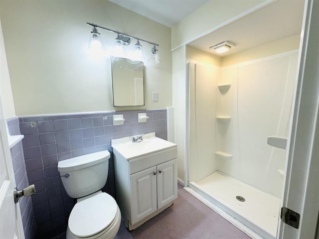 bathroom featuring walk in shower, vanity, tile walls, toilet, and tile patterned floors