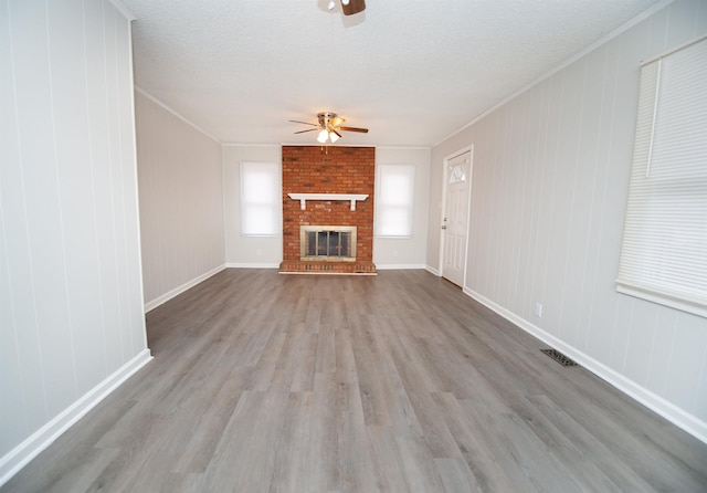 unfurnished living room featuring ceiling fan, ornamental molding, and light hardwood / wood-style floors