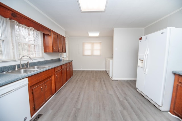 kitchen with white appliances, washer / dryer, sink, light wood-type flooring, and crown molding