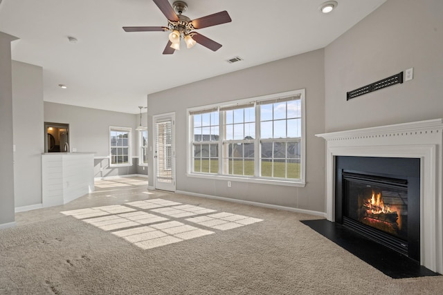 unfurnished living room featuring light carpet and ceiling fan