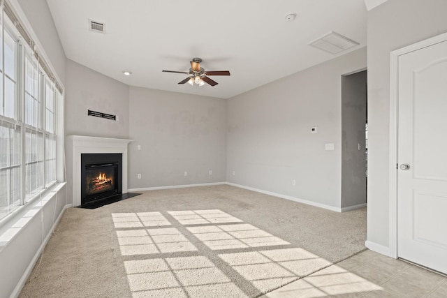 unfurnished living room featuring ceiling fan and light colored carpet