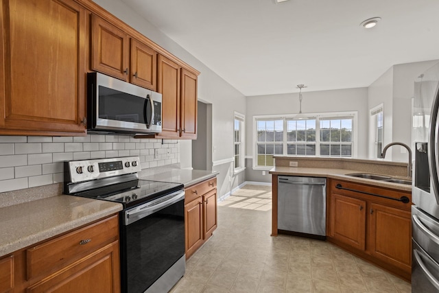 kitchen featuring decorative backsplash, sink, pendant lighting, and stainless steel appliances