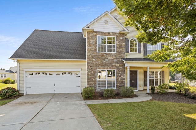 view of front of home featuring a front lawn, a garage, and covered porch