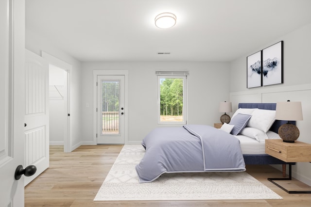 bedroom with light hardwood / wood-style floors, a closet, and access to outside