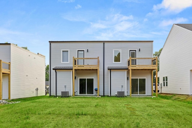 rear view of property with a balcony, a yard, and central air condition unit