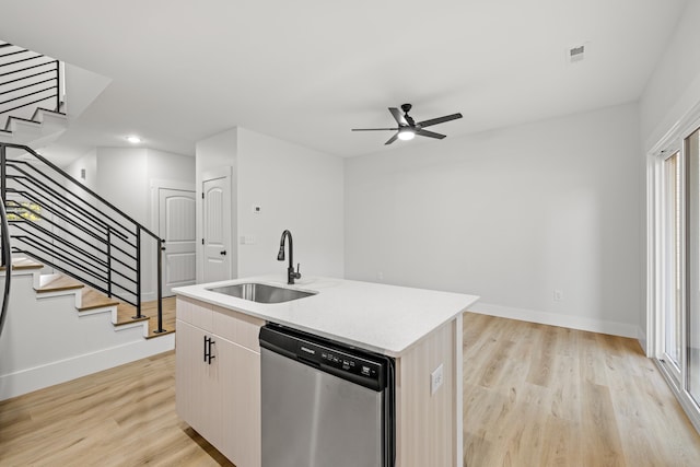 kitchen with ceiling fan, dishwasher, sink, a kitchen island with sink, and light wood-type flooring