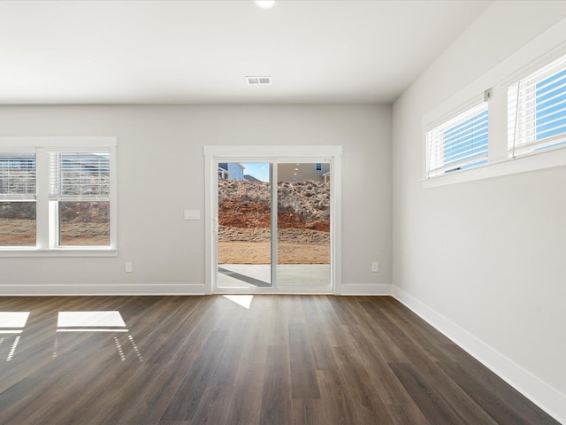 unfurnished room featuring visible vents, plenty of natural light, and baseboards