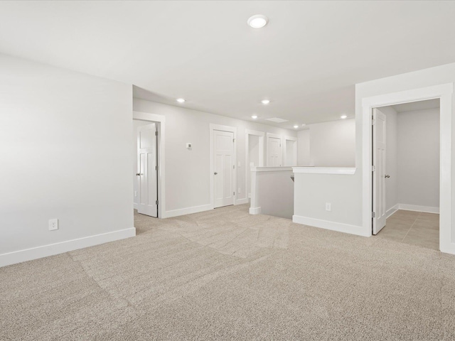 unfurnished room featuring recessed lighting, light colored carpet, and baseboards