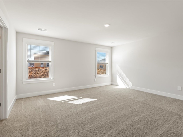 unfurnished room with carpet floors, recessed lighting, visible vents, and baseboards