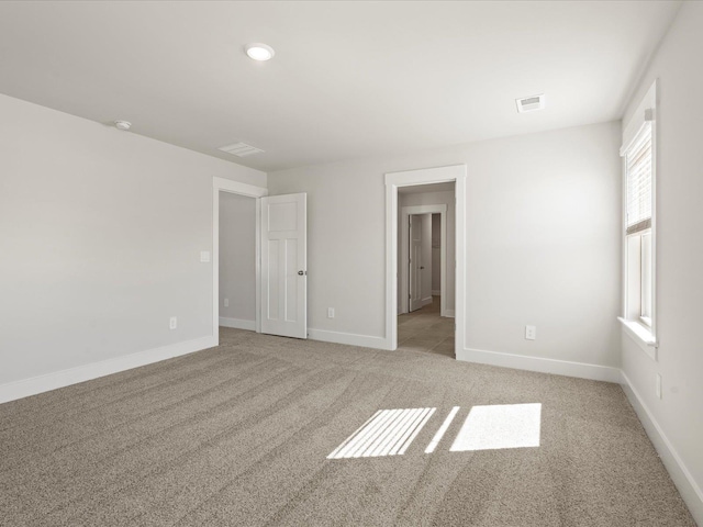 unfurnished bedroom featuring light carpet, visible vents, and baseboards