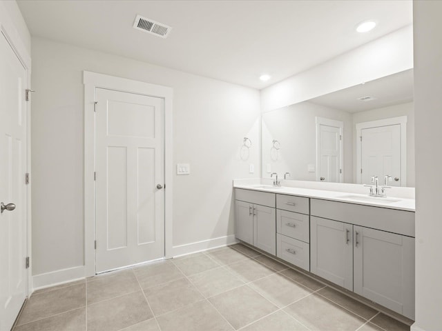 bathroom with double vanity, tile patterned flooring, a sink, and visible vents