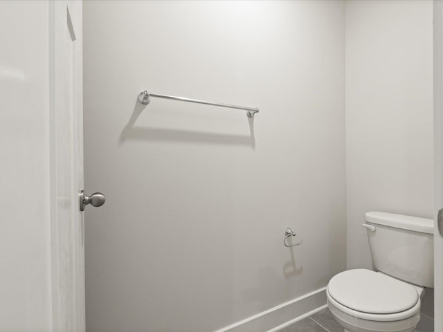 bathroom with toilet, baseboards, and tile patterned floors