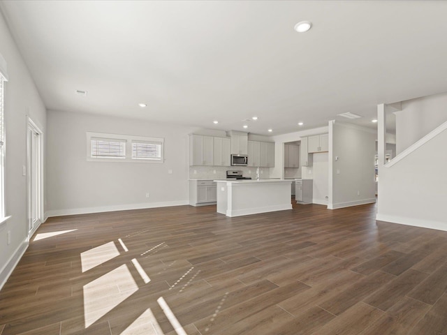 unfurnished living room featuring recessed lighting, dark wood-style flooring, and baseboards