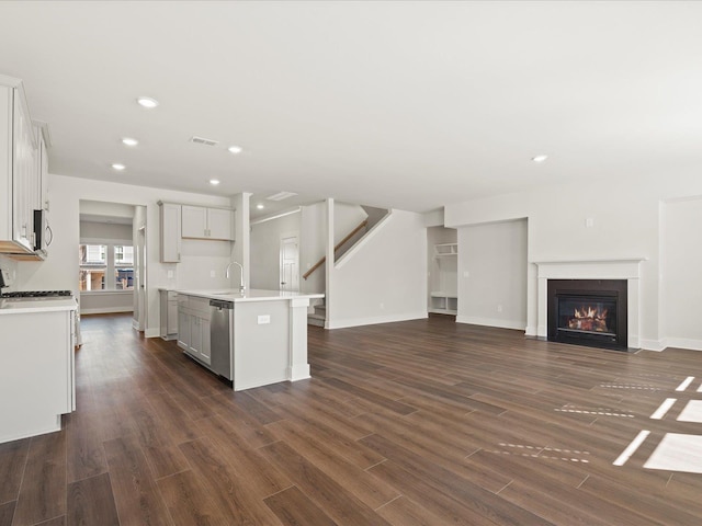 kitchen with open floor plan, stainless steel appliances, light countertops, and dark wood finished floors