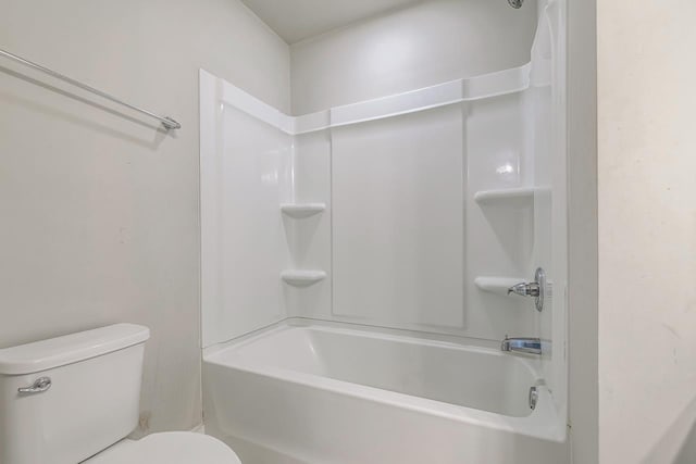 bathroom featuring tub / shower combination and toilet