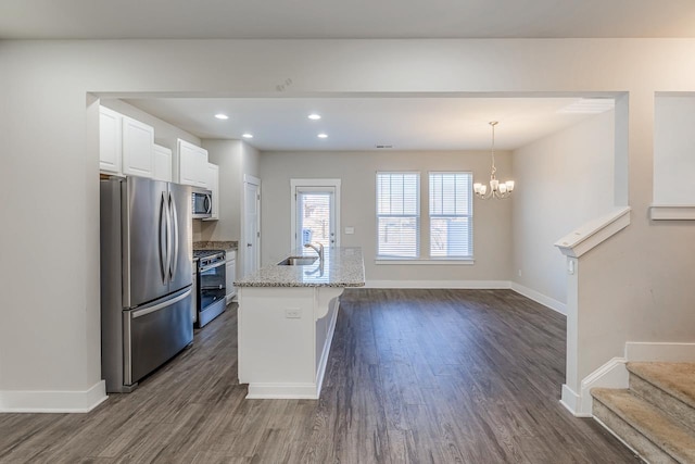 kitchen with pendant lighting, sink, white cabinetry, a kitchen island with sink, and appliances with stainless steel finishes