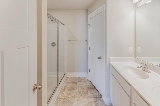 bathroom with a shower with shower door and vanity