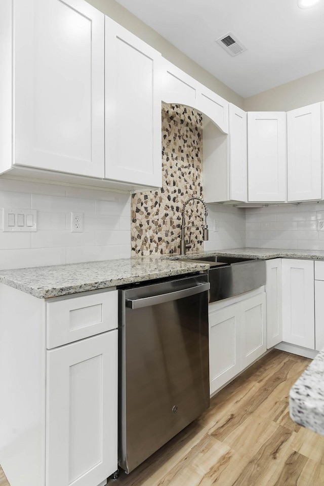 kitchen featuring white cabinets, dishwasher, light hardwood / wood-style flooring, and decorative backsplash