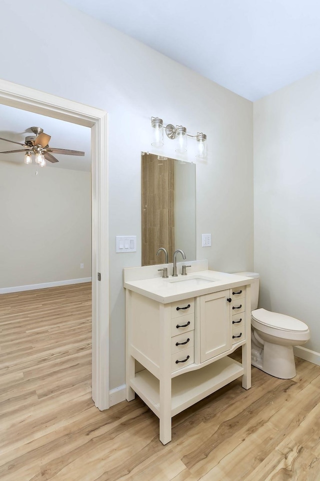 bathroom with toilet, ceiling fan, hardwood / wood-style flooring, and vanity