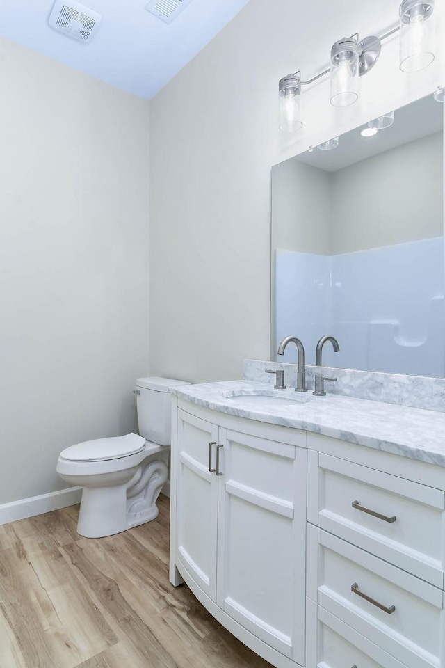 bathroom featuring vanity, toilet, and wood-type flooring