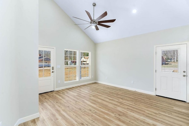 unfurnished living room featuring high vaulted ceiling, plenty of natural light, ceiling fan, and light wood-type flooring