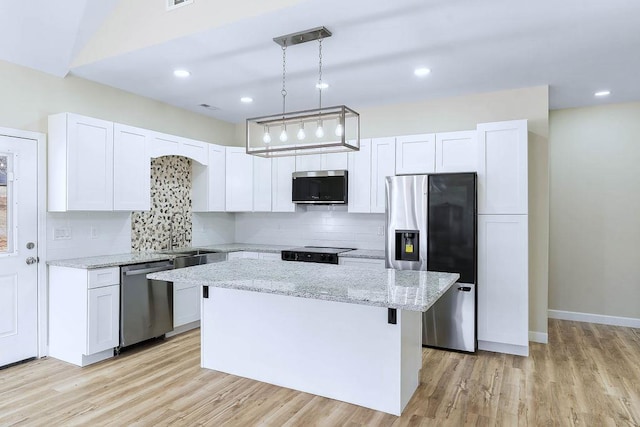 kitchen with a center island, stainless steel appliances, white cabinetry, and pendant lighting