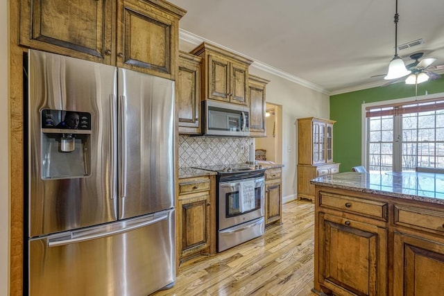 kitchen featuring light wood-type flooring, light stone countertops, ornamental molding, decorative backsplash, and stainless steel appliances