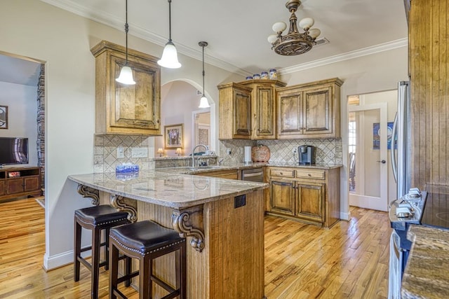 kitchen featuring kitchen peninsula, decorative backsplash, a breakfast bar, and light stone countertops