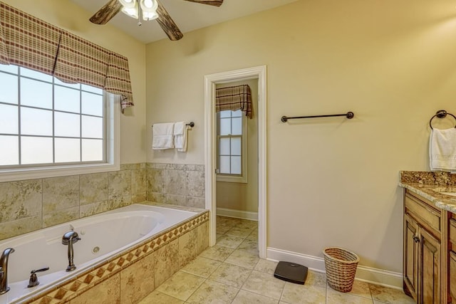 bathroom with ceiling fan, tiled tub, vanity, and tile patterned flooring