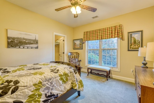 bedroom with a closet, ceiling fan, a spacious closet, and light carpet