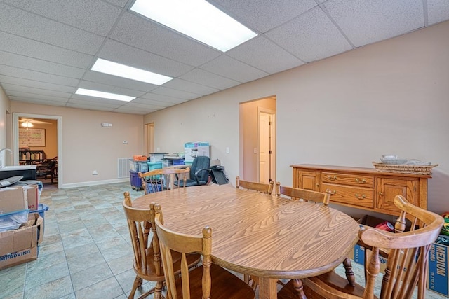 dining space featuring a drop ceiling