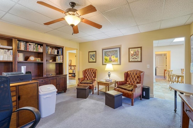 office area with light colored carpet, a drop ceiling, and ceiling fan