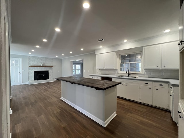 kitchen with sink, white cabinetry, a center island, and tasteful backsplash