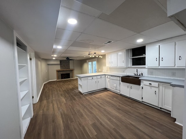 kitchen with sink, white cabinetry, kitchen peninsula, and dark wood-type flooring